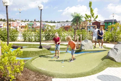 Two children and parents on the minigolf course in the LEGOLAND vacation village