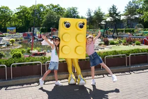 Two children in LEGOLAND with large LEGO brick figure in yellow color