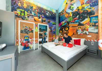 Father and son on a bed in the LEGOLAND vacation village racing driver room