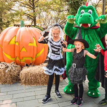 Park dragon Olli with dressed-up children on Halloween at LEGOLAND Deutschland