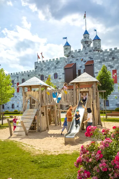 LEGOLAND Holiday Village Playground with family in front of Knight's Castle Hotel