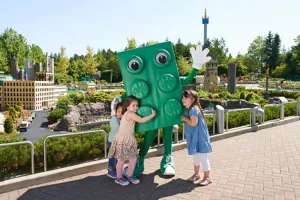 Children in LEGOLAND with large LEGO brick figure in green color