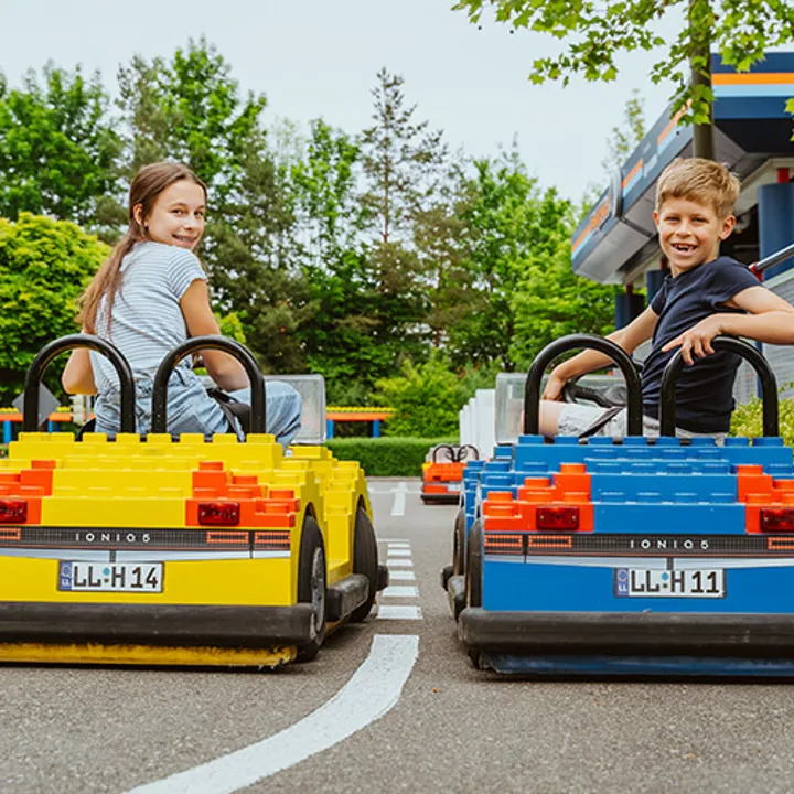 Two children drive cars in the LEGOLAND driving school