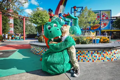 Park dragon Olli hugs a girl at LEGOLAND Deutschland